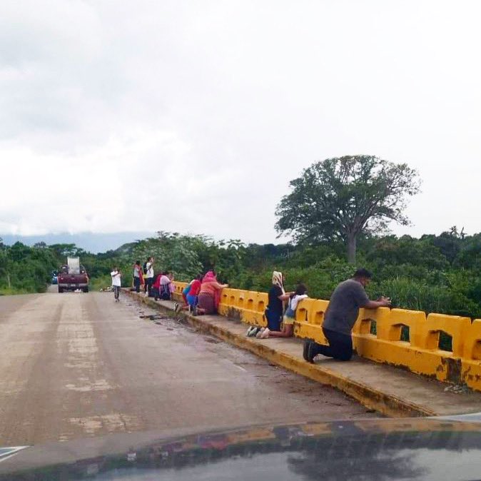 Ciudadanos se arrodillan y oran en uno de los puentes del Canal Maya en