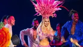 Karol G en el escenario usando el tocado de plumas 