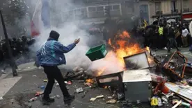 Manifestación frente a barricada en llamas